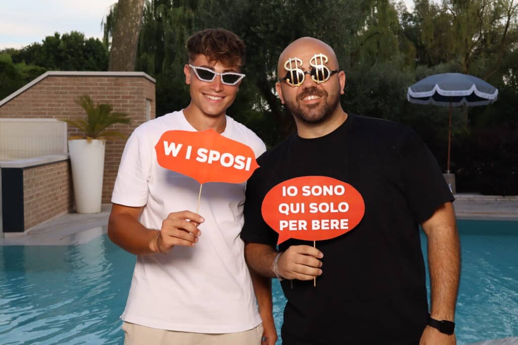 ospiti davanti al photobooth con occhiali divertenti e props