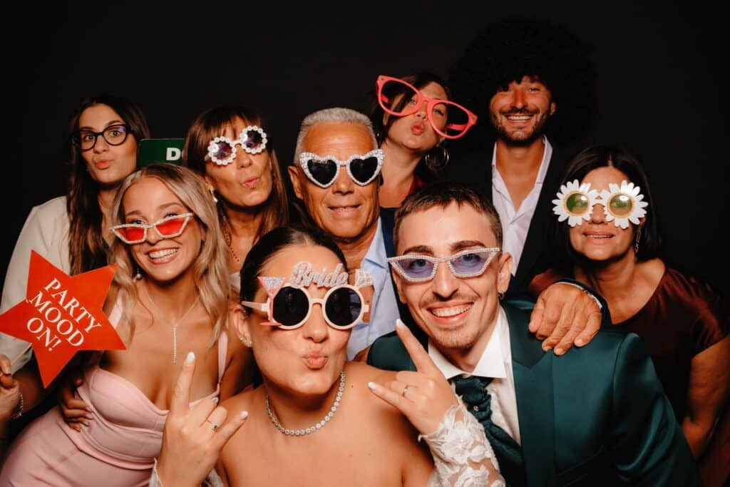 Invitati con occhiali e accessori divertenti al photo booth